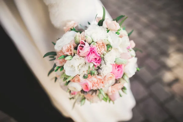 Menyasszony gazdaság nagy és gyönyörű esküvői csokor virágokkal — Stock Fotó