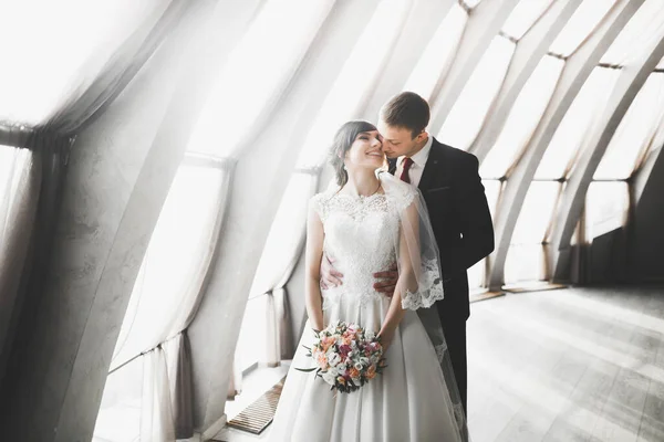 Ravissant couple de mariage heureux, mariée avec longue robe blanche posant dans la belle ville — Photo