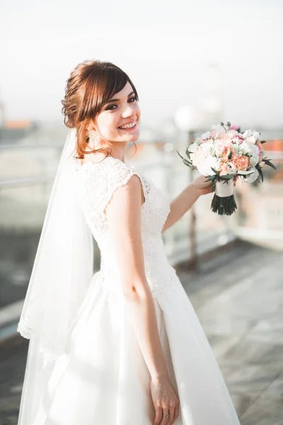 Retrato de noiva deslumbrante com cabelos longos posando com grande buquê — Fotografia de Stock