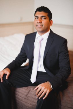 Güzel adam, damat poz veriyor ve düğüne hazırlanıyor.