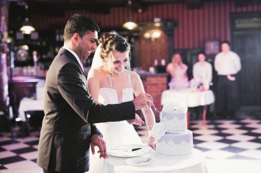 Gelin ve damat düğün pastasını kesiyor.