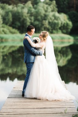 Güzel gelin ve damat evlendikleri gün kucaklaşıp öpüşüyorlar.