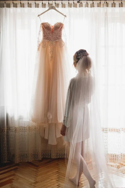 Hermosa novia con vestido de novia de moda con plumas con maquillaje de lujo deleite y peinado, estudio sesión de fotos interior — Foto de Stock