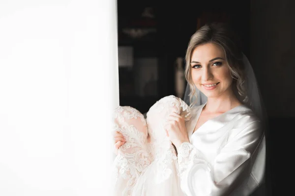 Schöne Braut trägt Mode Hochzeitskleid mit Federn mit luxuriösem Genuss Make-up und Frisur, Studio Indoor Fotoshooting — Stockfoto