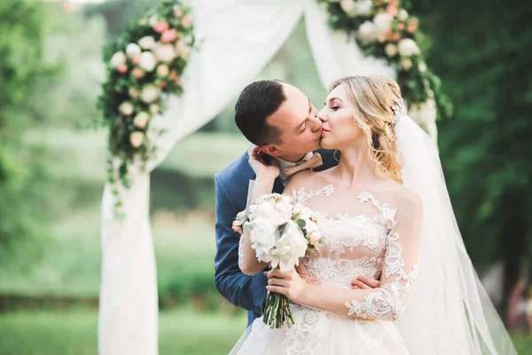 Belle mariée et marié embrasser et embrasser le jour de leur mariage à l'extérieur — Photo