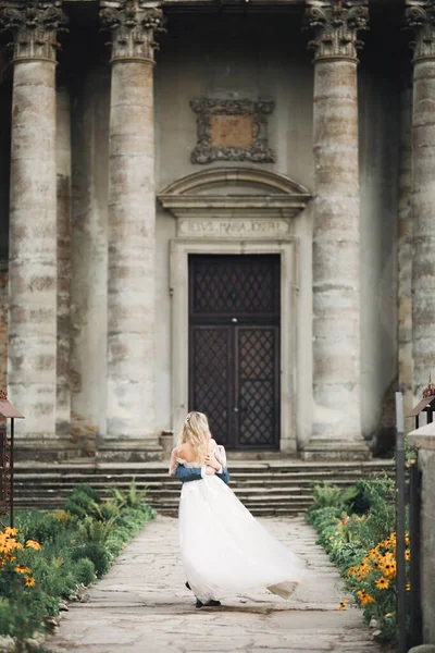 Beau couple de mariage tournant près du grand bâtiment historique — Photo