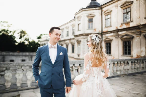 Sunshine portrait of happy bride and groom near old historical castle — Stock Photo, Image