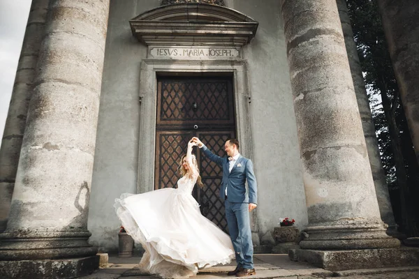 Bella coppia di nozze appena sposati e ballando vicino vecchio edificio — Foto Stock