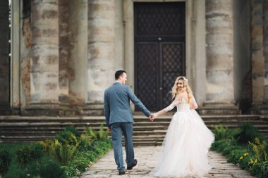 Düğün fotoğrafı çekimi. Gelin ve damat şehirde yürüyorlar. Birbirlerine sarılıp bakan evli çiftler.