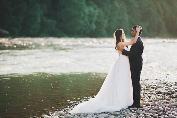 La pareja de boda en la naturaleza se está abrazando. Hermosa modelo chica en vestido blanco. Hombre de traje —  Fotos de Stock