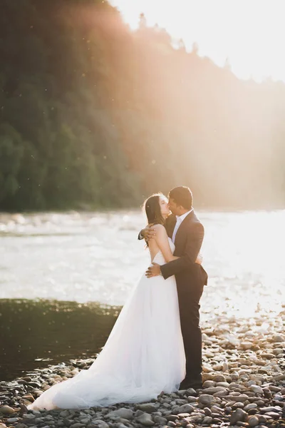 Schöne Braut und Bräutigam umarmen und küssen sich am Hochzeitstag im Freien — Stockfoto