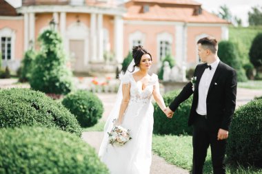 Güzel gelin ve damat evlendikleri gün kucaklaşıp öpüşüyorlar.