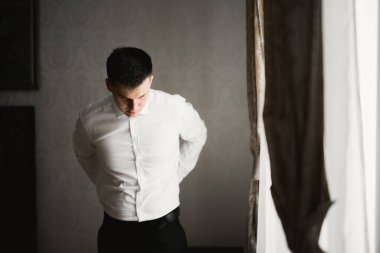 Güzel adam, damat poz veriyor ve düğüne hazırlanıyor.