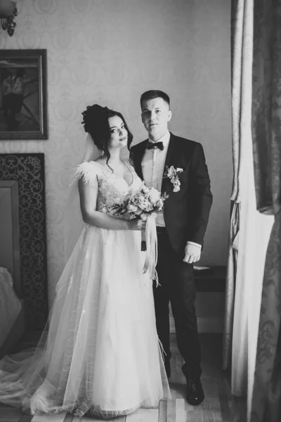 Casal jovem bonito posando com buquê de flores nas mãos — Fotografia de Stock