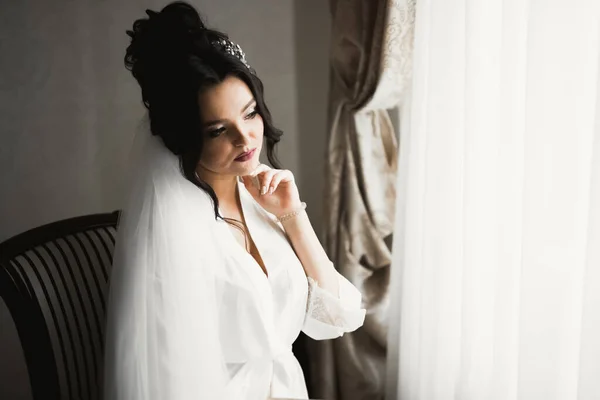 Belle mariée portant une robe de mariée de mode avec des plumes avec luxe délice maquillage et coiffure, studio séance photo d'intérieur — Photo