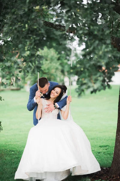 Romantikus, tündérmese, boldog friss házaspár ölelés és csókolózás a parkban, fák a háttérben — Stock Fotó