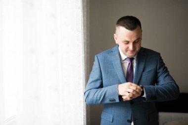 Güzel adam, damat poz veriyor ve düğüne hazırlanıyor.