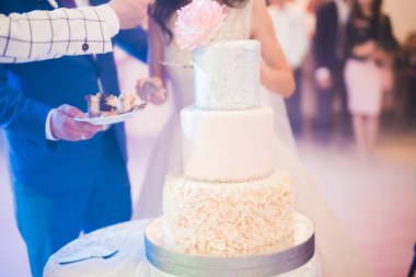 Gelin ve damat düğün pastasını kesiyor.