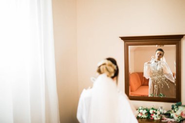 Tüylü, lüks makyaj, saç stili, stüdyo içi fotoğraf çekimi olan güzel bir gelin.