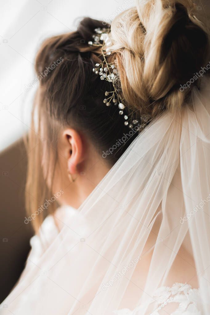 Luxury bride in white dress posing while preparing for the wedding ceremony