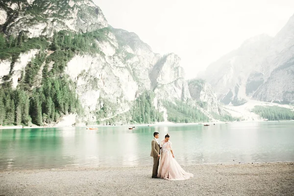 Casal jovem perto de um belo lago nas montanhas. Amantes se amam bem e sorriem — Fotografia de Stock