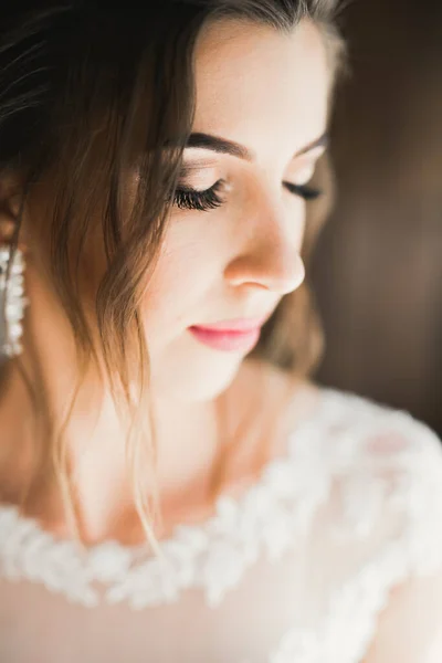 Linda noiva em roupão posando e se preparando para o rosto cerimônia de casamento em uma sala — Fotografia de Stock