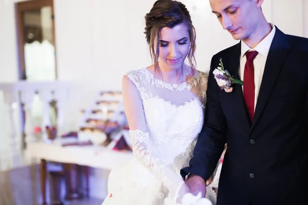 Panna młoda i pan młody na weselu kroją tort weselny — Zdjęcie stockowe