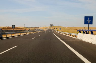 İspanya 'da kırsal kesimde trafik işaretleriyle asfalt bir yolda ilerliyor..