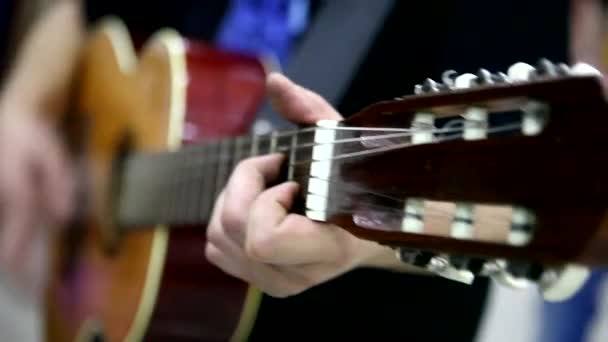 Музыкант играет на акустической гитаре — стоковое видео