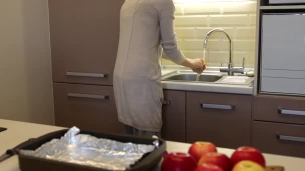 Ung tjej i köket tvätta äpplena — Stockvideo