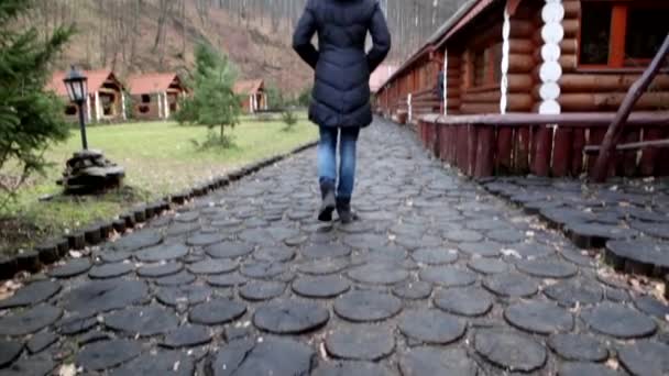 Fille marche le long des maisons en bois Vue arrière.3 — Video