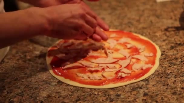 Чоловік робить піцу, кладе начинку на тісто — стокове відео