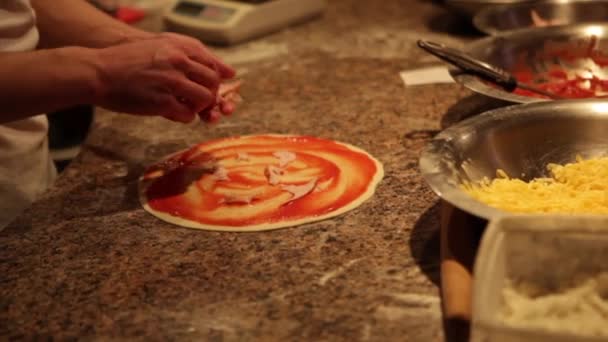 L'uomo fa la pizza, mette il ripieno sullo strato di pasta 2 — Video Stock