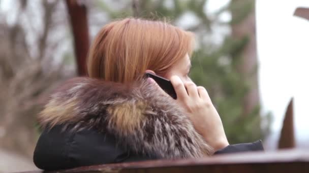 Fille balançant une balançoire en bois et parlant sur Smartphone — Video