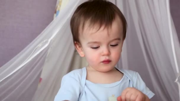 Un bébé garçon debout dans un lit bébé — Video