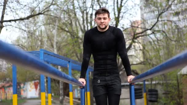 Atleta haciendo ejercicios en barras irregulares — Vídeo de stock