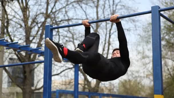 Exercises on the Bar, the Athlete Makes a Horizontal Suspension With Earth Outdoors — Stock Video