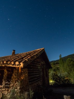 Rustik kır evinde gece yıldızların altında