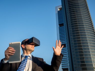 Sanal gerçeklik gözlükle bir tablet bir iş merkezi ile iş adamı