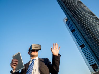 Sanal gerçeklik gözlükle bir tablet bir iş merkezi ile iş adamı