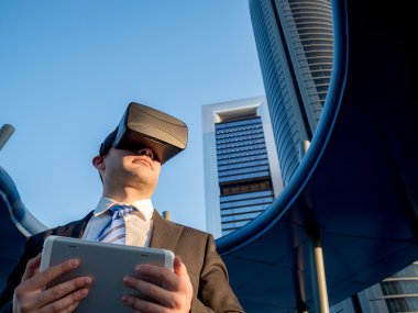 Sanal gerçeklik gözlükle bir tablet bir iş merkezi ile iş adamı