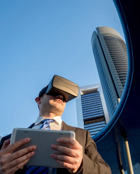 Businessman using virtual reality glasses with a tablet in a business center — Stock Photo, Image