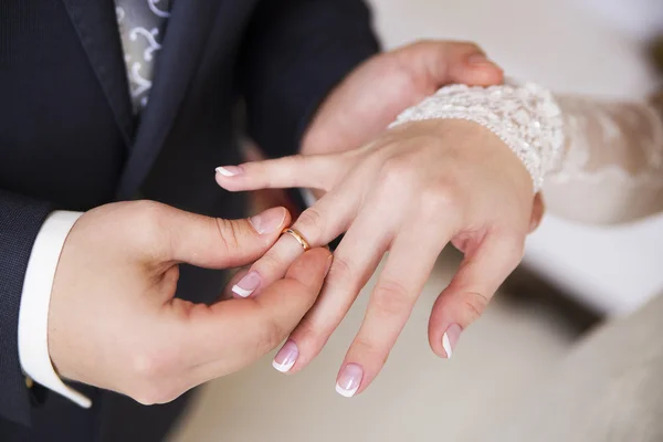 Groom wears bride a ring on the finger Stock Photo