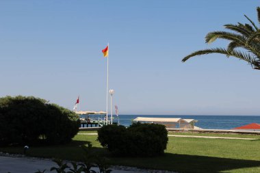 Tepeleri ve dubaları olan berrak bir deniz kıyısı.