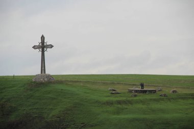 Yeşil çimenli bir arazide büyük bir haç.