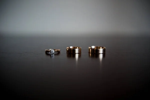 暗い木製のテーブルの上に結婚指輪 — ストック写真