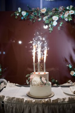 Işıklı bir masada güzel bir düğün pastası.