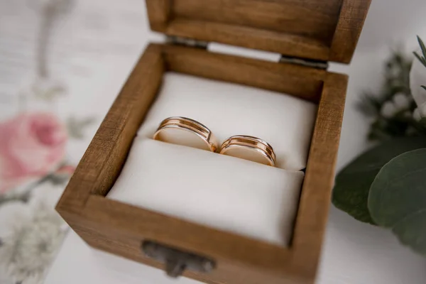桌上一个木制盒子里的金婚戒指 — 图库照片