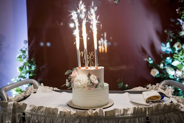 a beautiful wedding cake on a table with lights