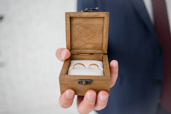 wooden box for wedding rings in the hands of groom